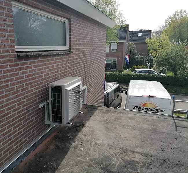 Buitenunit van airco aan muur met ZPN installaties werkbus