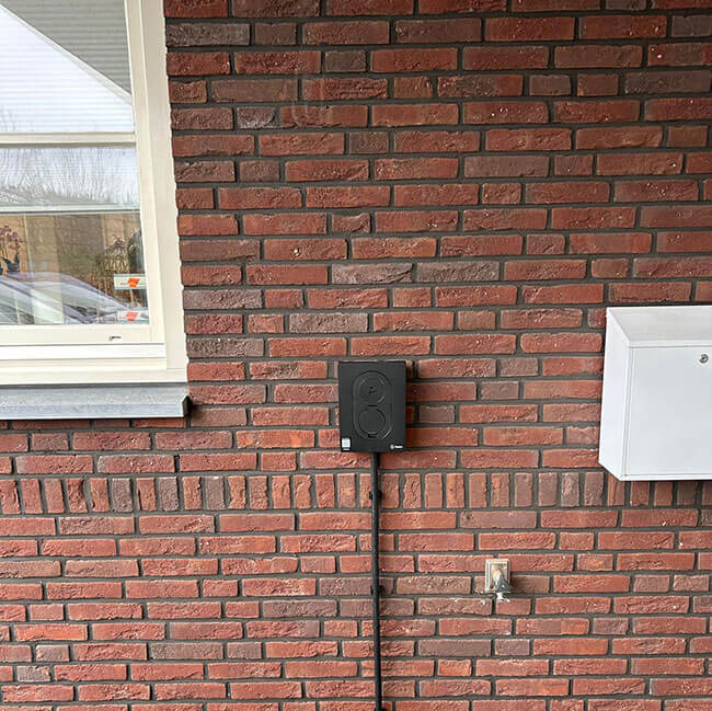 Laadpaal aan muur bij woningcorporatie